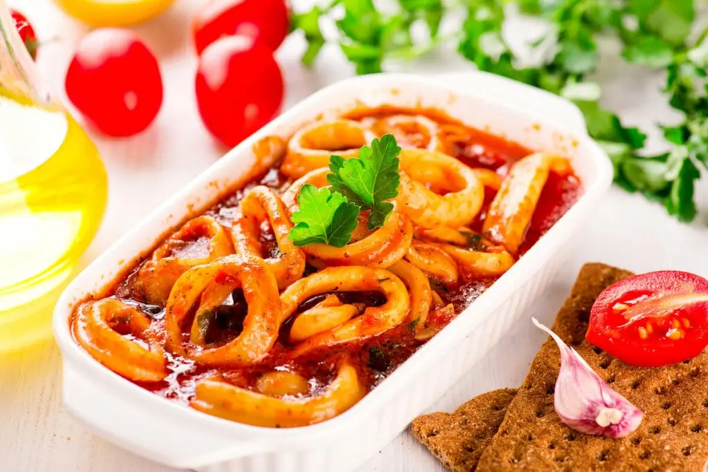 Travessa branca com anéis de lula com molho vermelho