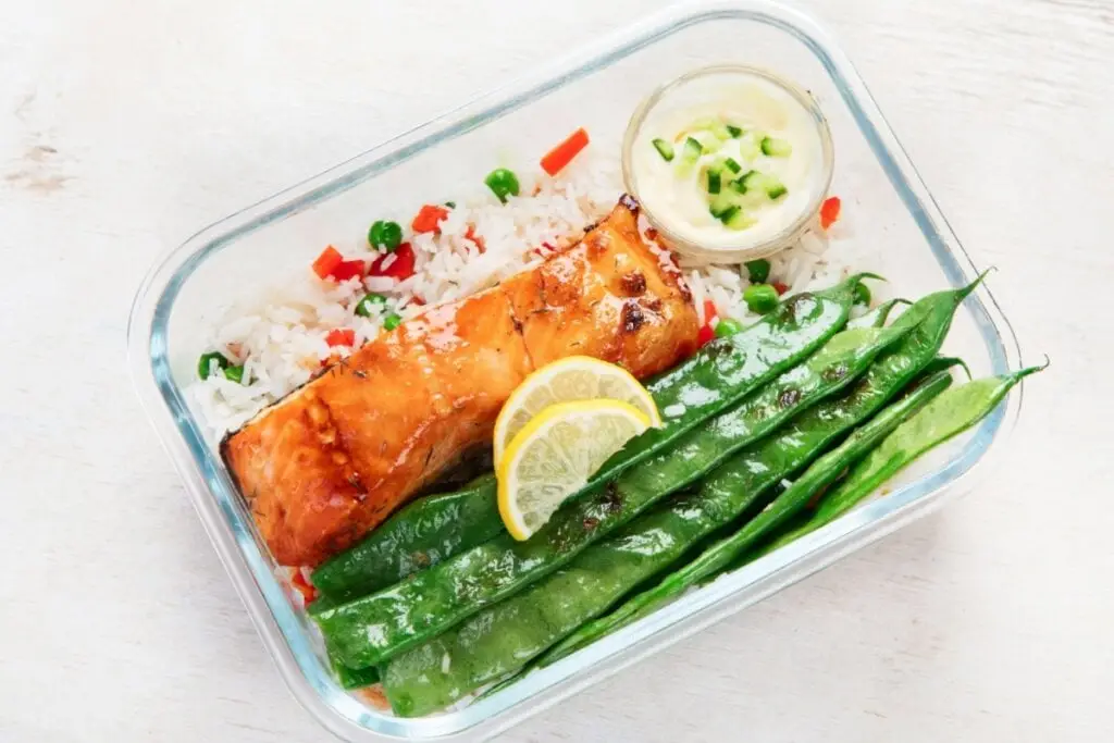 Marmita de vidro com salmão, arroz e legumes