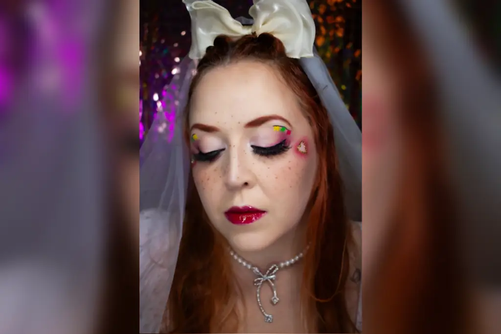 Mulher trajada de noiva para festa junina com maquiagem rosa com detalhes de bandeirolas coloridas