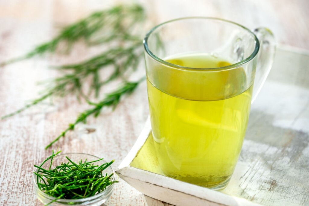 Xícara de vidro com chá de cavalinha com chá-verde