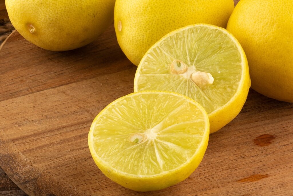 Limão-galego cortado ao meio em cima de mesa de madeira