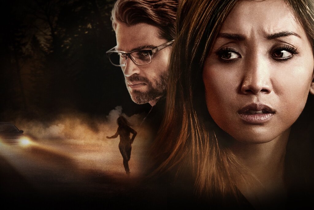 Mulher olhando assustada enquanto um homem aparece ao lado e há uma estrada com neblina