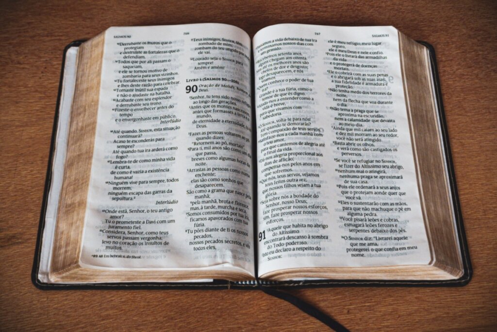 Bíblia aberta em salmos 90 em cima de uma mesa de madeira 