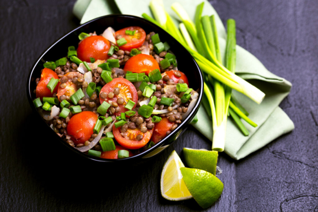 Salada de lentilha, tomate, cebola e cebolinha em pote preto