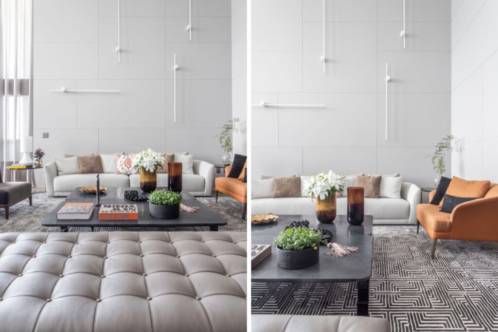 Sala de estar com parede branca com textura ao fundo, na frente, um sofá branco com almofadas e mesa de centro preta 