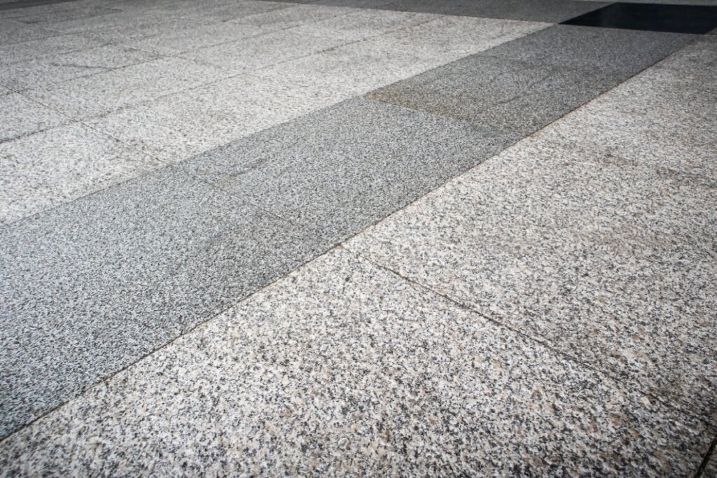 Foto com foco em um piso de cimento com pedras naturais