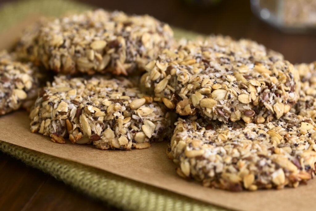 Biscoitos com linhaça, aveia e chia empilhados em uma superfície marrom