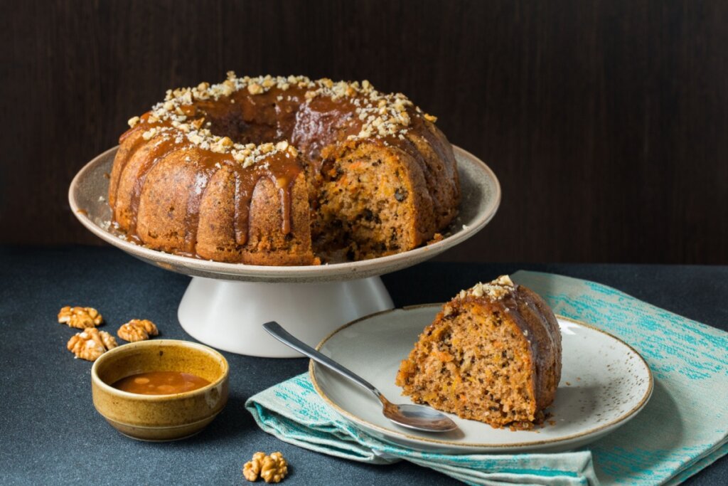 Travessa branca com bolo de cenoura com nozes e calda de caramelo 