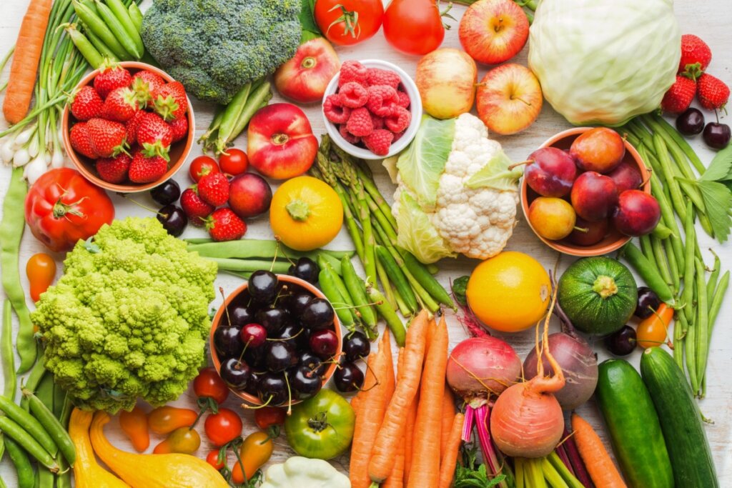 Variedade de frutas e legumes em cima de uma mesa branca 