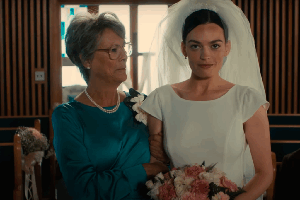 Noiva segurando um buquê e sendo acompanhada por uma mulher mais velha durante uma cerimônia