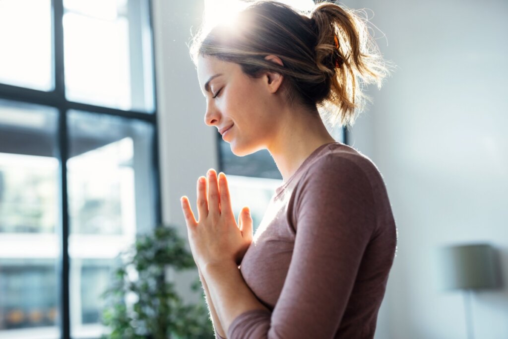 Jovem orando na sala de casa