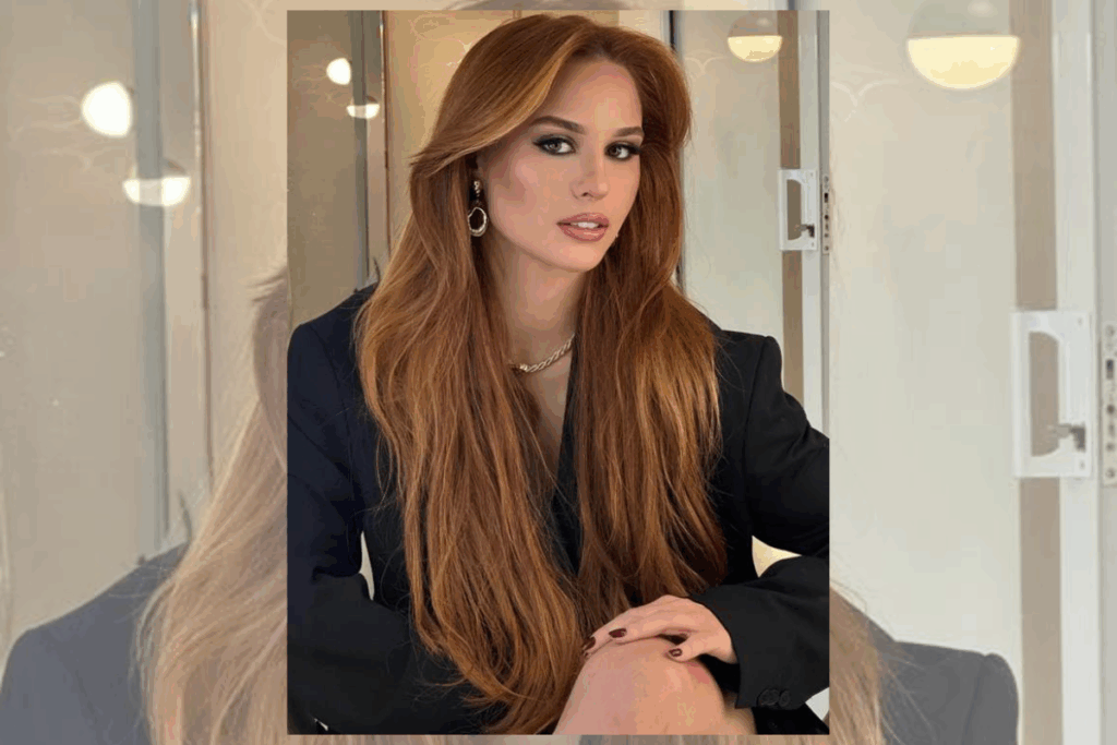 Mulher com cabelo longo, em tons de marrom usando blazer preto