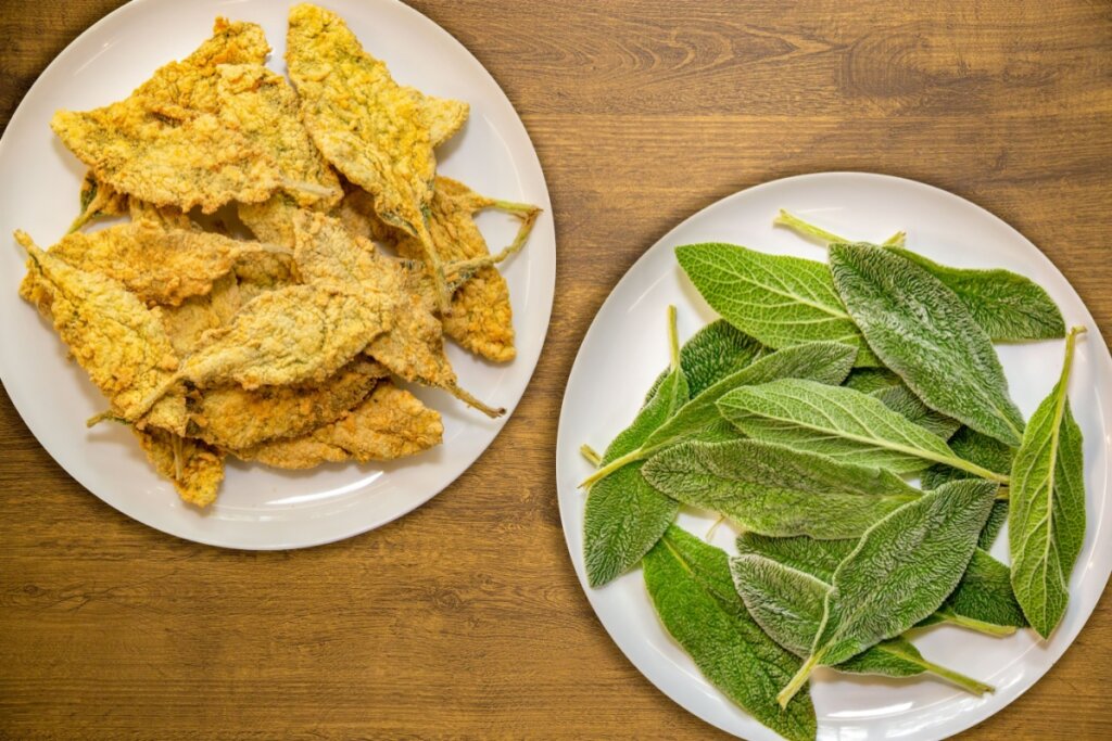 dois pratos brancos. um com folhas de peixinho-da-horta empanadas. outro com folhas verdes de peixinho-da-horta