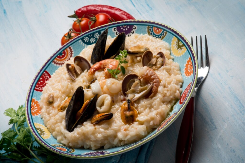 Risoto com frutos do mar  em um prato azul-claro 