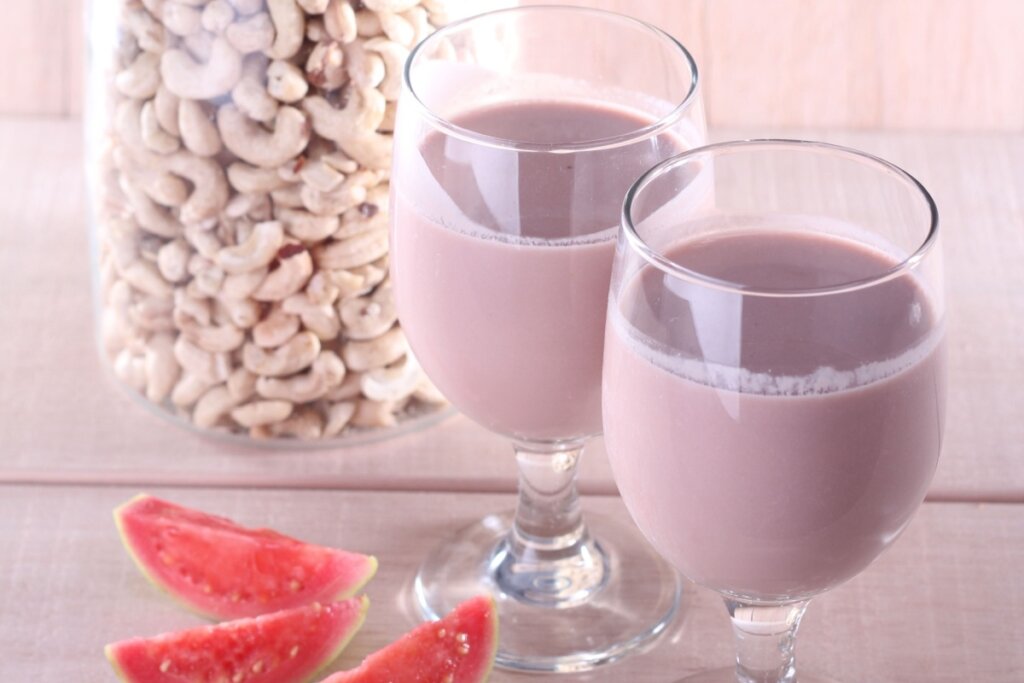 Duas taças com vitamina de goiaba com castanha-de-caju