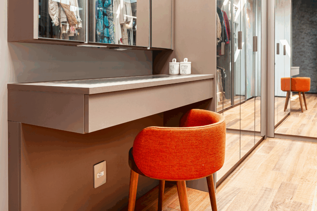 Closet com móveis em bege e cadeira laranja