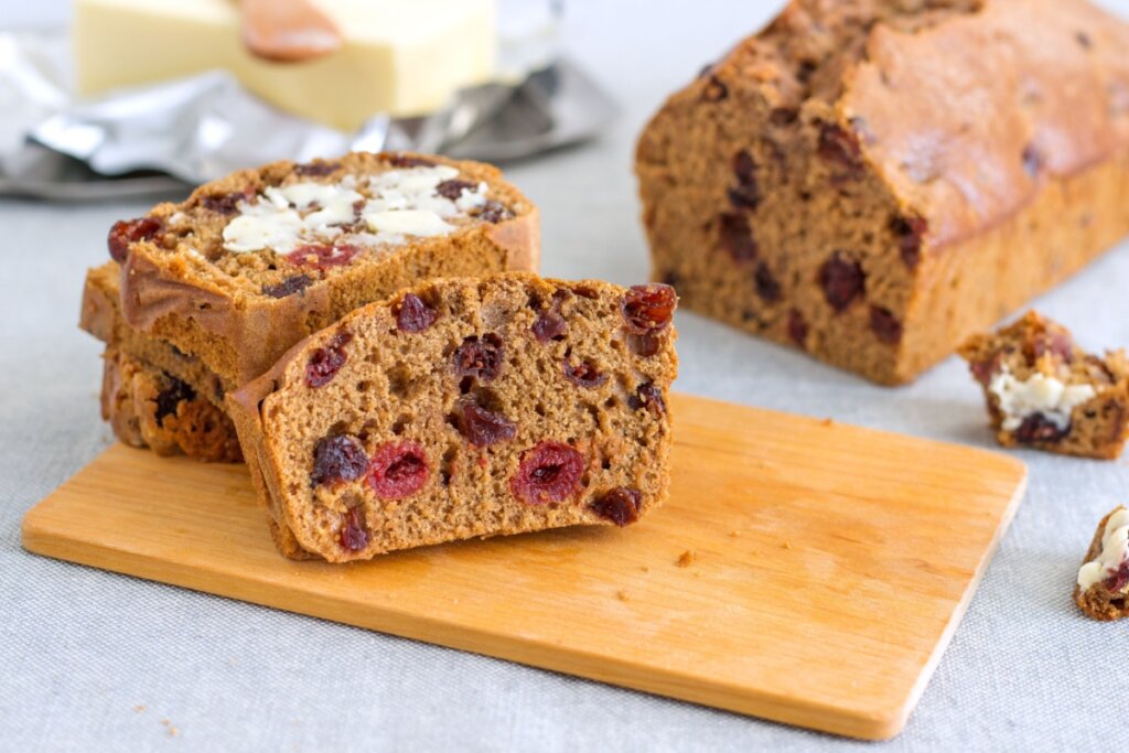 Pão de frutas Barmbrack servido em tábua de madeira com manteiga