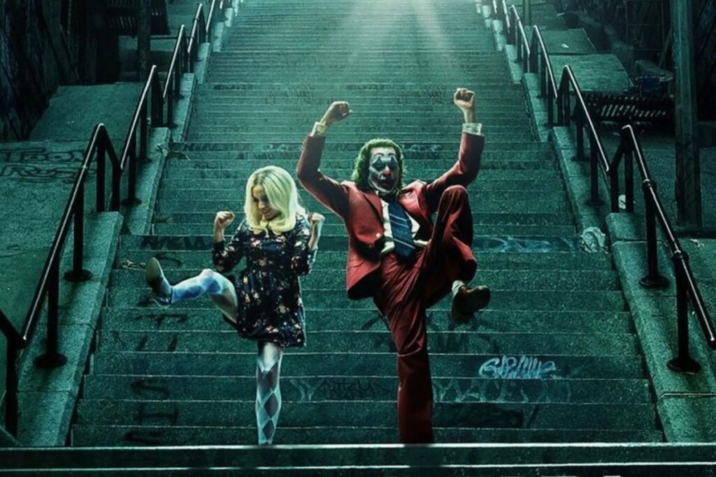 O Coringa e Arlequina dançam em uma escadaria externa de pedra sob uma luz forte que vem do topo. O Coringa usa seu terno vermelho clássico e maquiagem de palhaço, enquanto a Arlequina usa um vestido curto florido e meia-calça estilizada. Ambos estão com os braços levantados em uma pose coreografada.