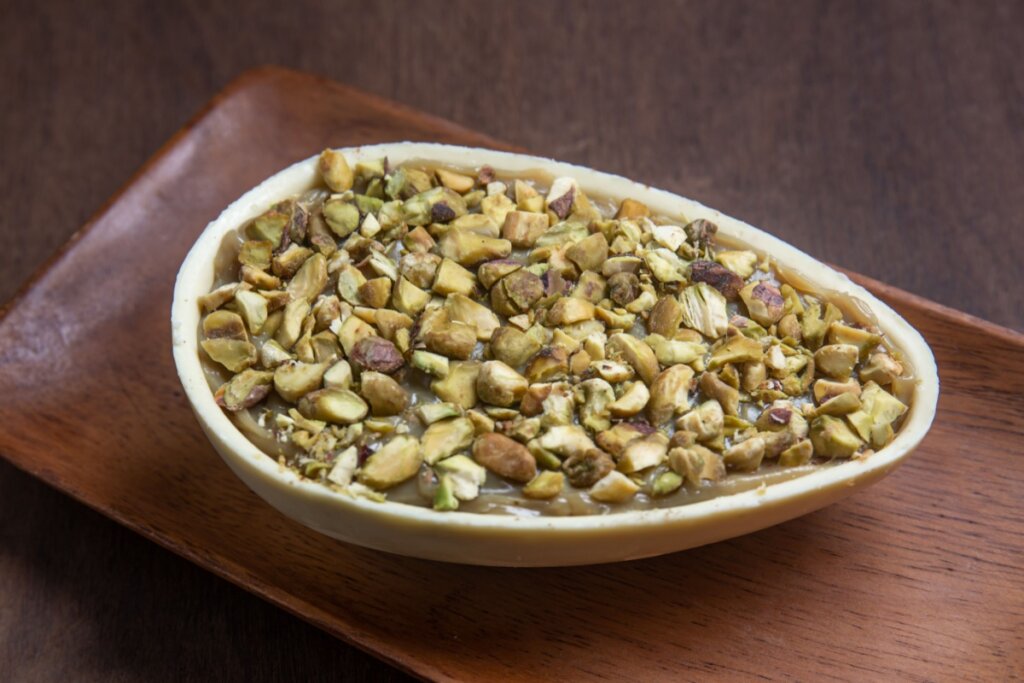 Ovo de Páscoa de colher de pistache em uma travessa marrom