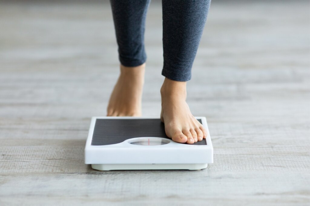 Pessoa subindo em uma balança branca