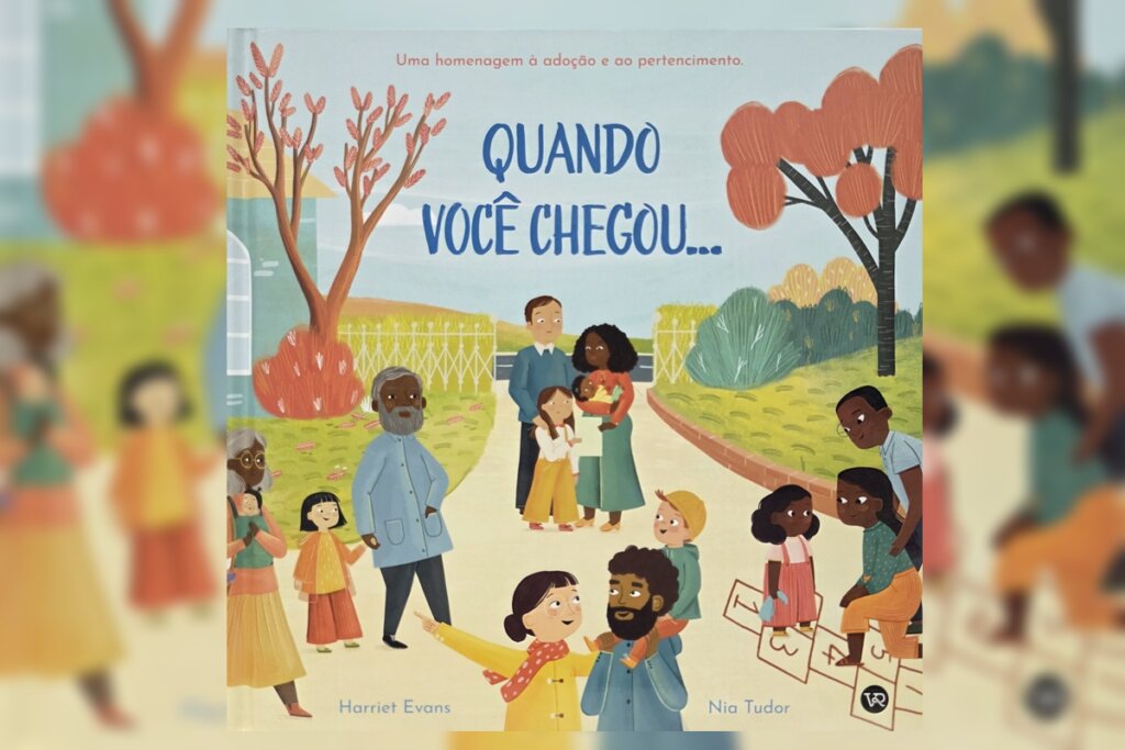 Ilustração calorosa mostrando diversas famílias de diferentes etnias em um parque ou jardim com árvores de folhas alaranjadas. No centro, um casal segura um bebê. Crianças brincam de amarelinha e idosos caminham ao redor. No topo, a frase: "Uma homenagem à adoção e ao pertencimento". Título central: "QUANDO VOCÊ CHEGOU...".