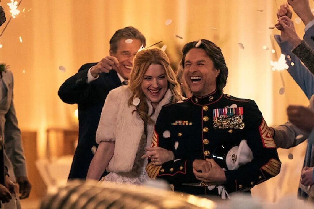 Jack e Mel celebram em um ambiente festivo, cercados por pessoas segurando faíscas (sparklers) e pétalas brancas caindo. Jack usa seu uniforme de gala da Marinha (azul marinho com medalhas e listras douradas) e Mel usa um casaco de pele sintética branca sobre um vestido. Ambos estão rindo e visivelmente felizes.