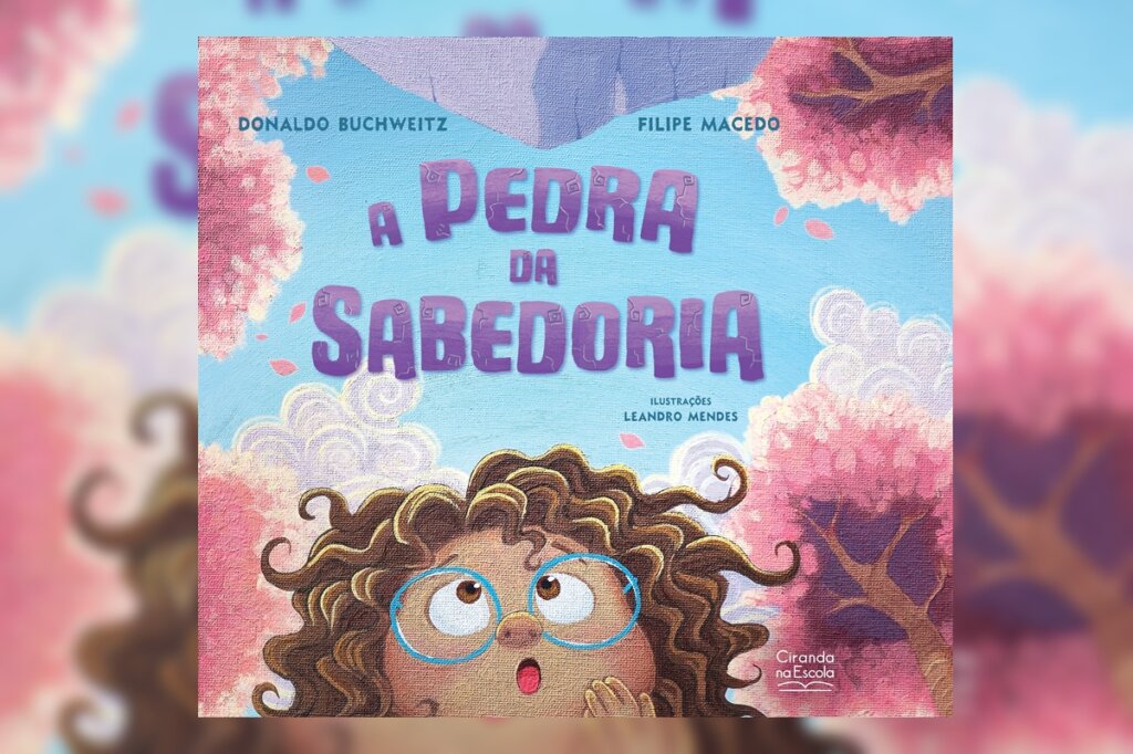 ilustração colorida e vibrante. Na parte inferior, uma menina de cabelos cacheados castanhos e óculos azuis olha para cima com expressão de surpresa e boca aberta. O fundo tem árvores com copas rosas que lembram nuvens e um céu azul claro. O título "A PEDRA DA SABEDORIA" está centralizado em letras roxas estilizadas.