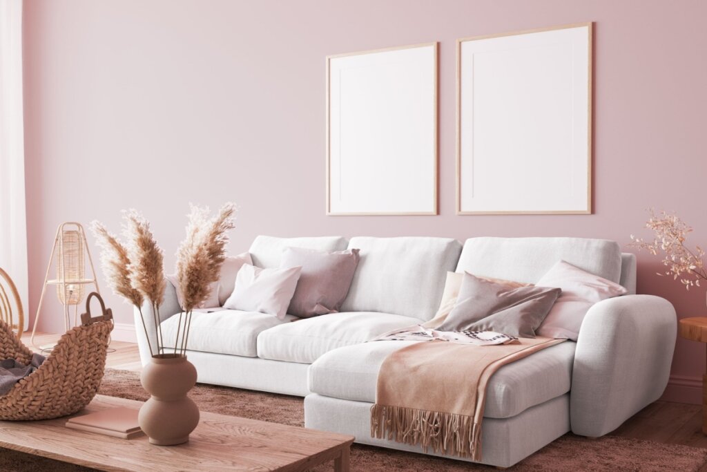 Sala de estar com sofá branco e parede rosa