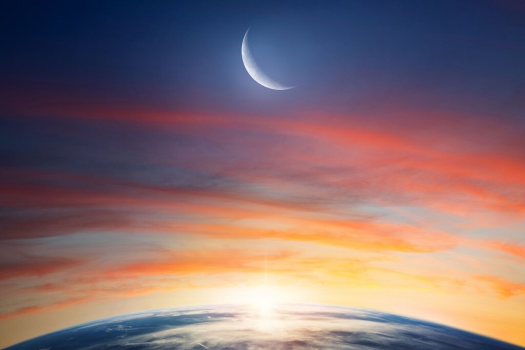 Lua Crescente fora da órbita da Terra durante o pôr do sol