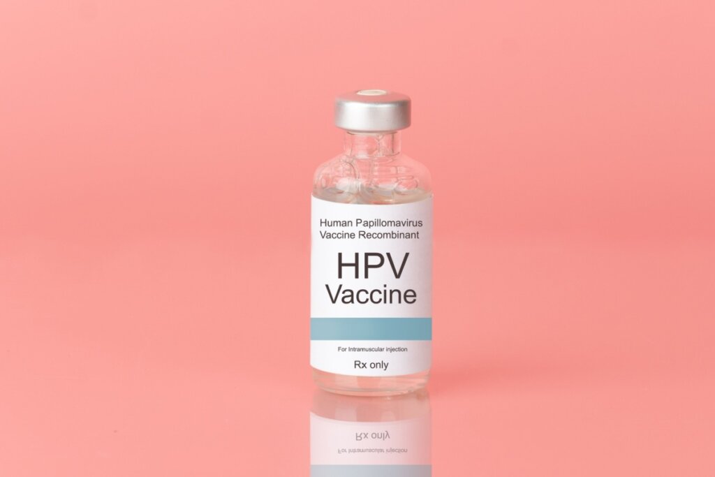 Ampola da vacina do HPV em fundo rosa-claro