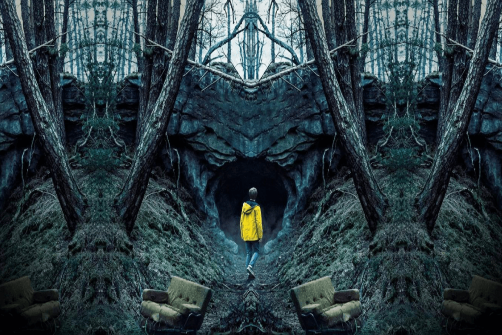 Jovem de calça jeans e casaco amarelo perto de caverna próxima a árvores