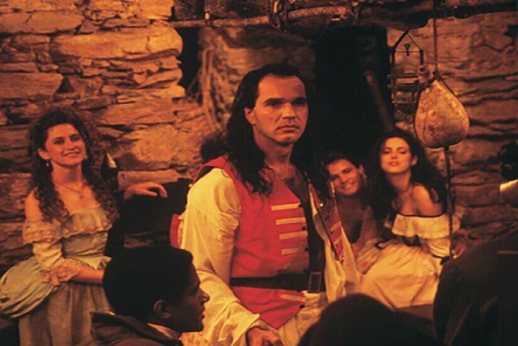 Cena do filme Tiradentes, em que o homem veste roupas da época e está acompanhado de um grupo da elite local de Minas Gerais