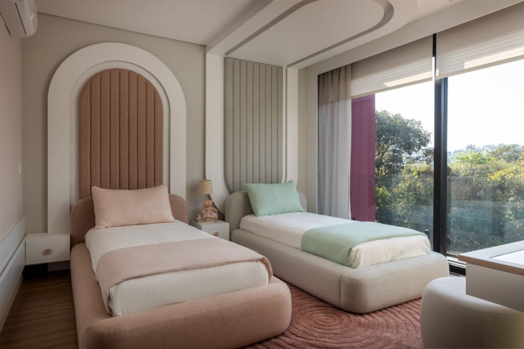 Quarto infantil com duas camas, cabeceiras com textura e janela do teto ao chão na lateral esquerda 