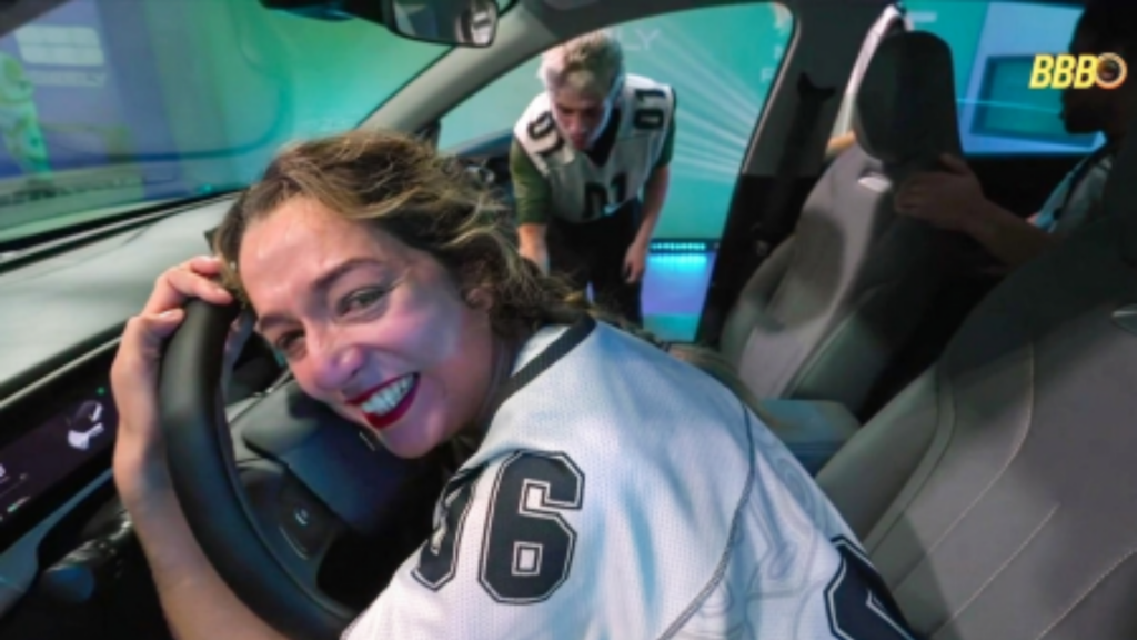 Samira sorrindo enquanto segura ovolante de um carro