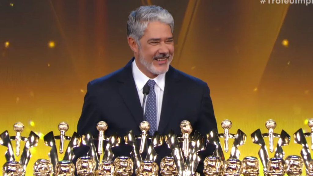 William Bonner sorri com várias estatuetas do Troféu Imprensa