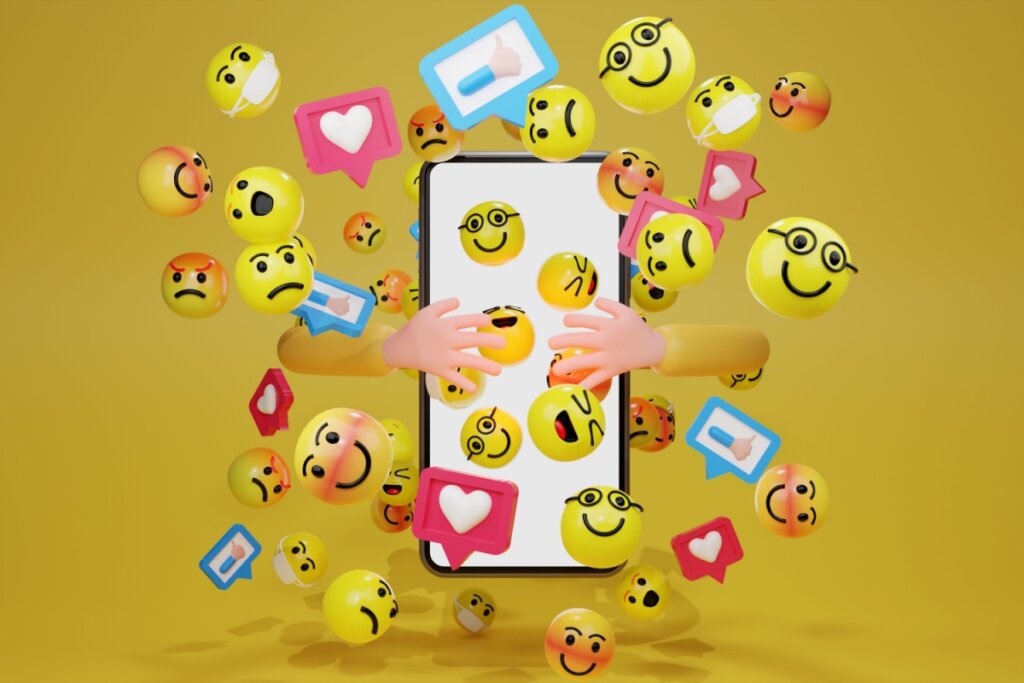 Ilustração de um celular com diversos emojis de reações diferentes, felizes, alegres com coração, rindo em fundo amarelo escuro