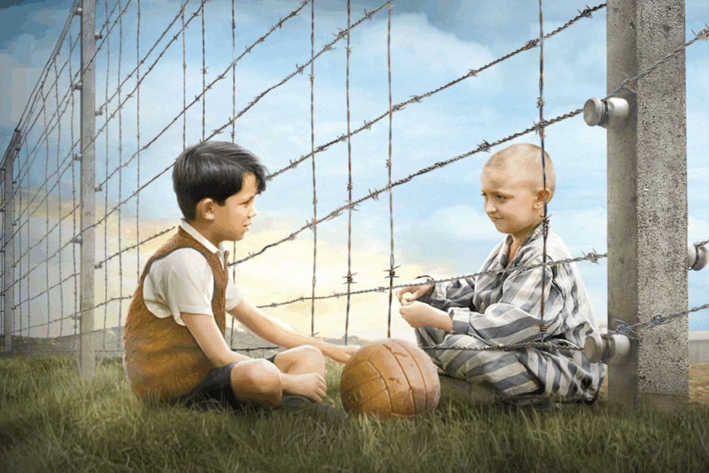 Dois meninos sentados dos lados opostos de uma cerca de arame farpado