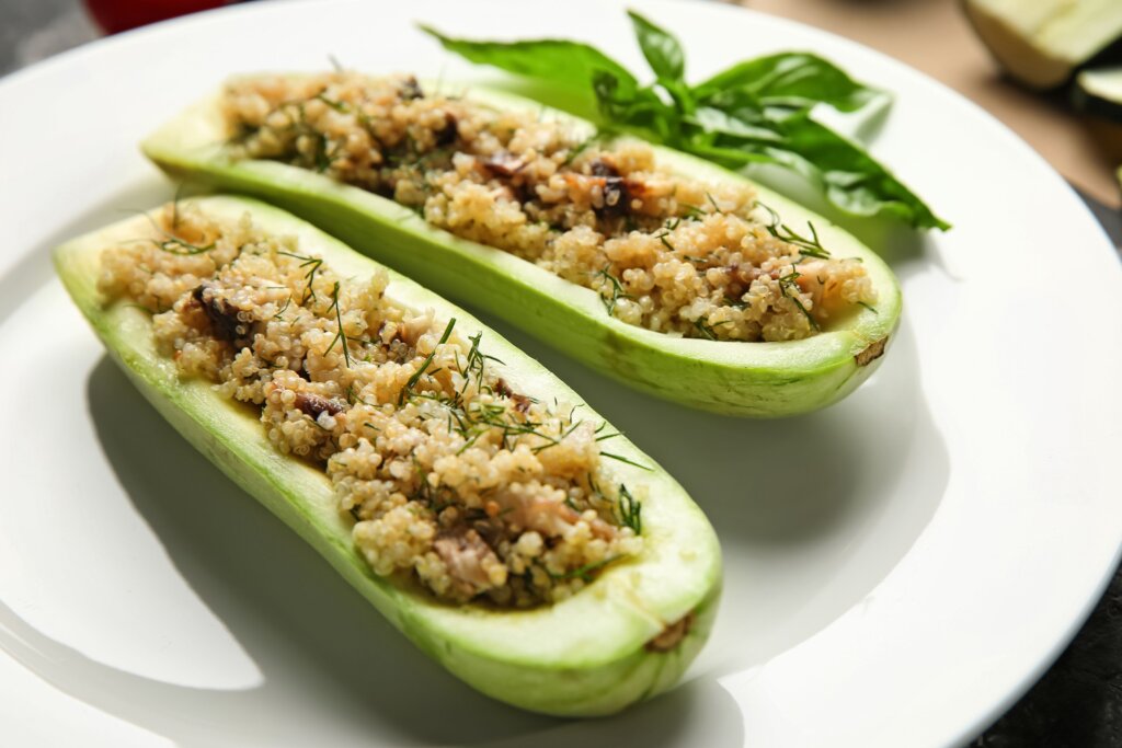 Abobrinhas recheadas com quinoa, cogumelos e endro servidas em prato branco
