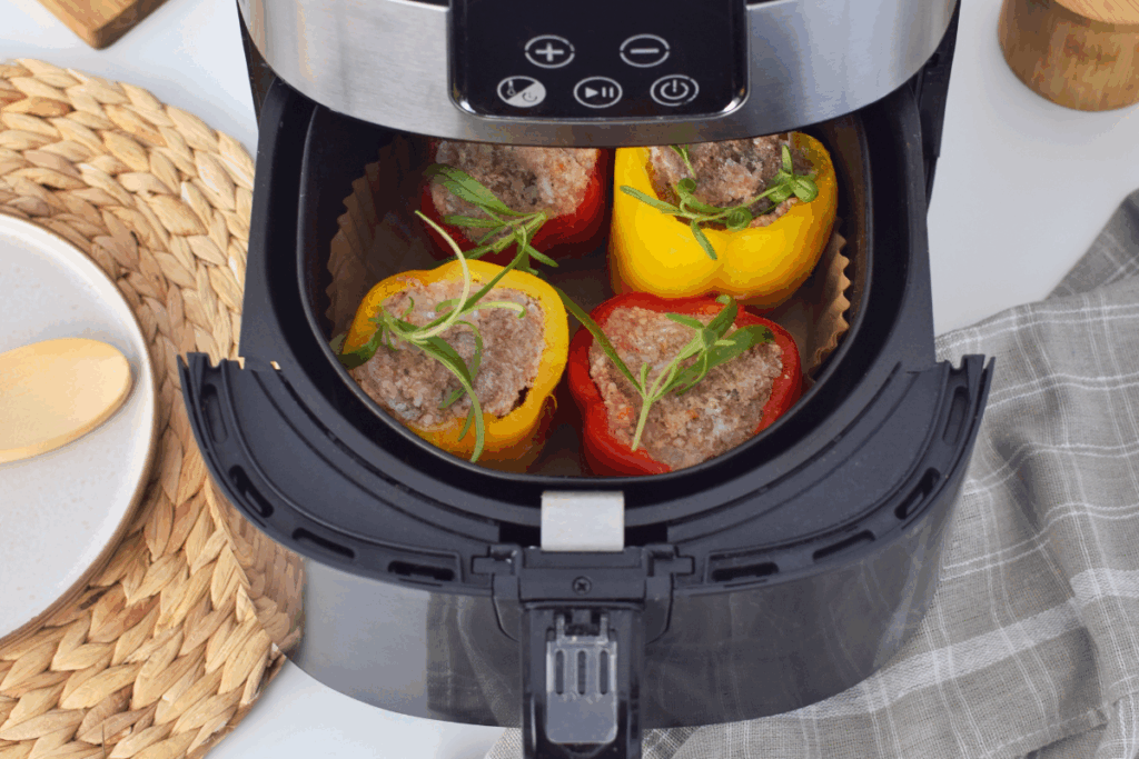 Pimentões amarelos e vermelhos recheados na air fryer em cima de bancada