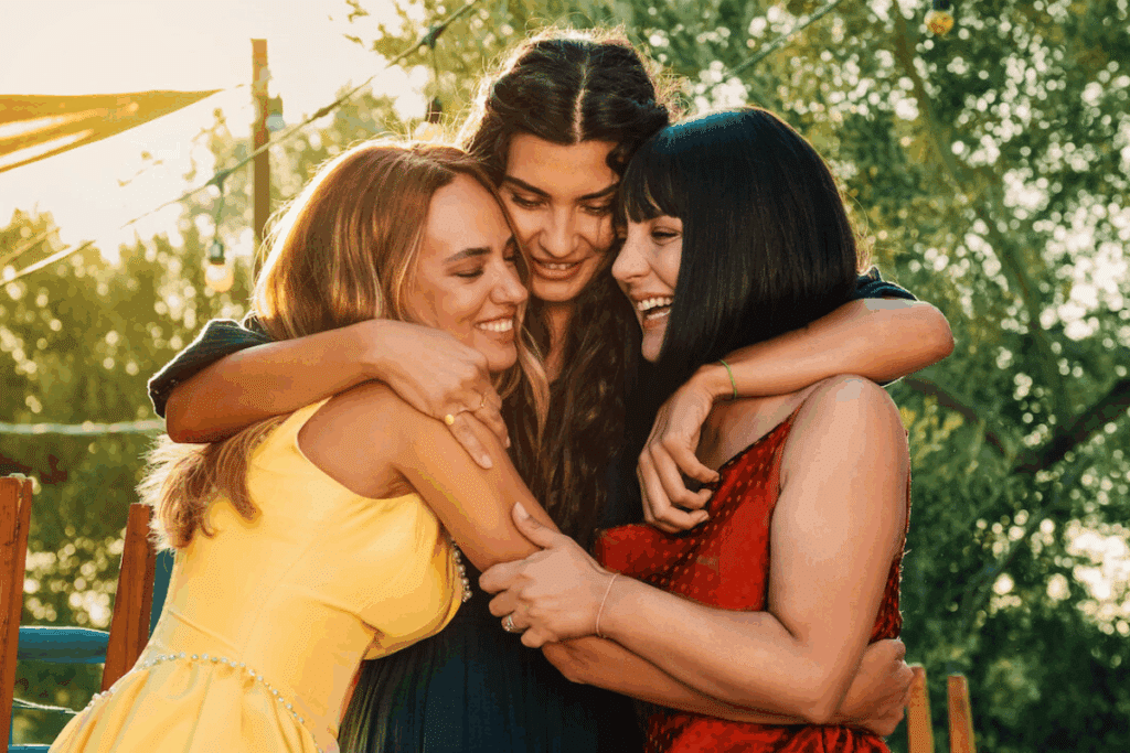 Protagonistas de "Uma Nova Mulher" se abraçando. Ao fundo, folhas verdes 