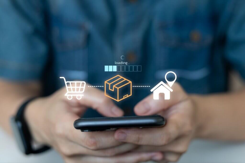 Mão segurando um celular com ilustração de compra e entrega online projetada acima da tela