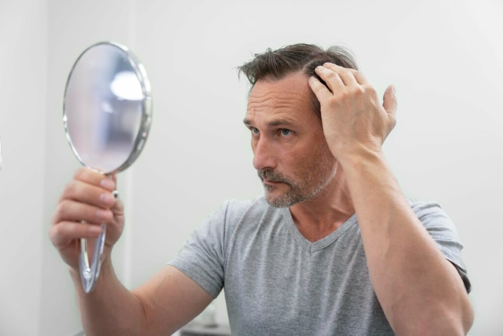 homem olhando o cabelo pelo espelho