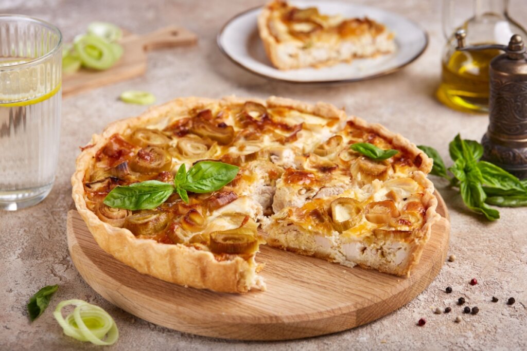 Quiche de frango com alho-poró em cima de uma tábua de madeira 