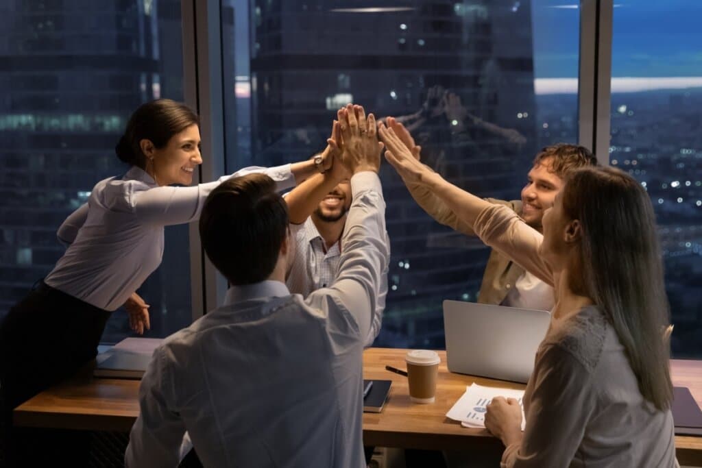 Pessoas em uma sala de reunião fazendo hi-five