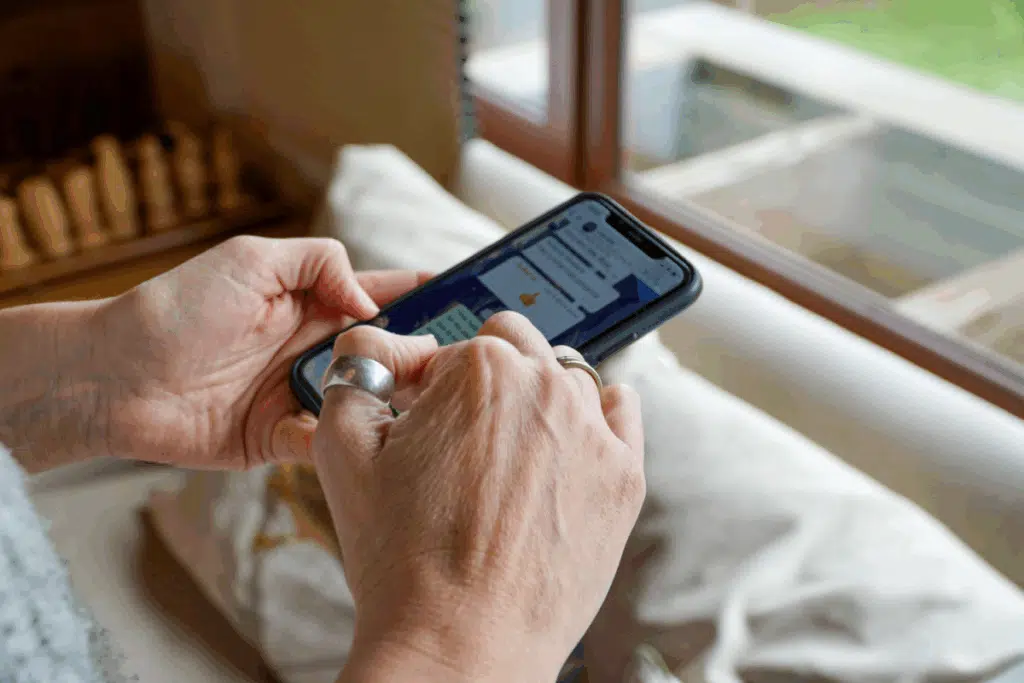 Mãos feminina mexendo em um celular logado no WhatsApp
