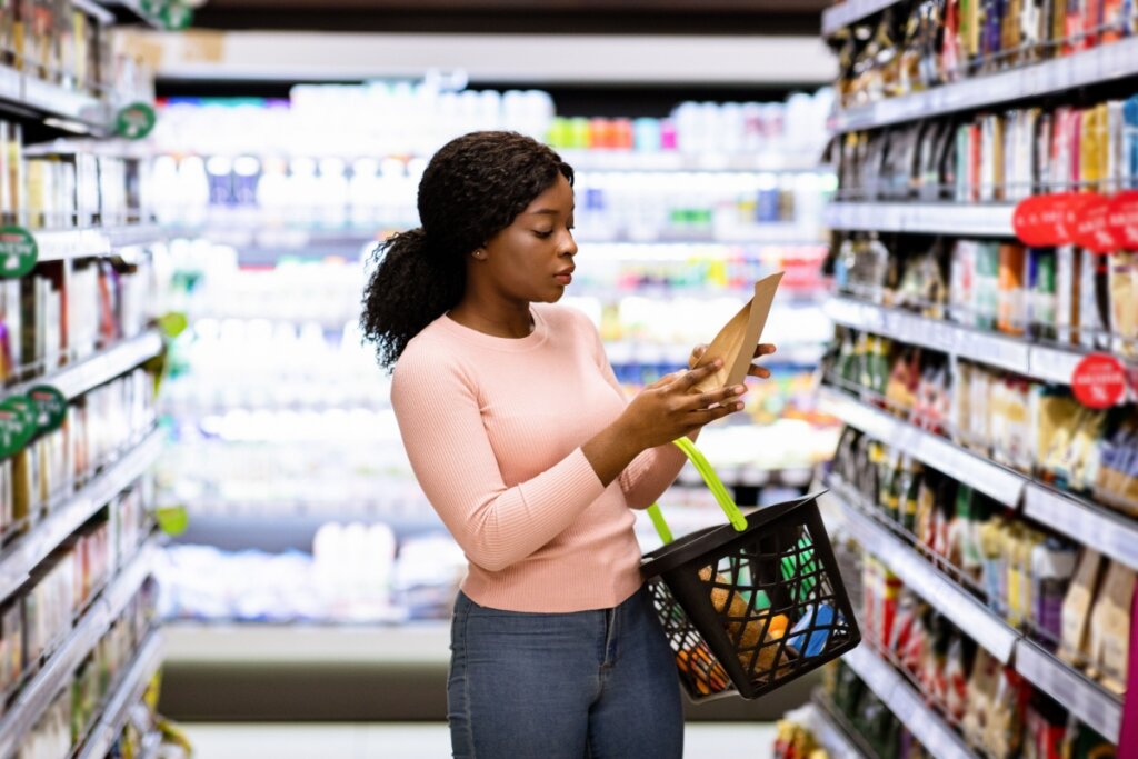 Mulher lendo rótulo de um produto no mercado