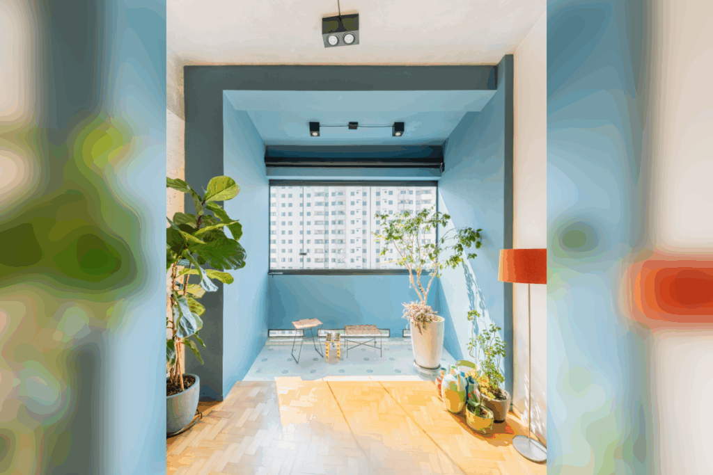 Espaço com paredes em azul, janela ao fundo, teto branco e plantas nas laterais 