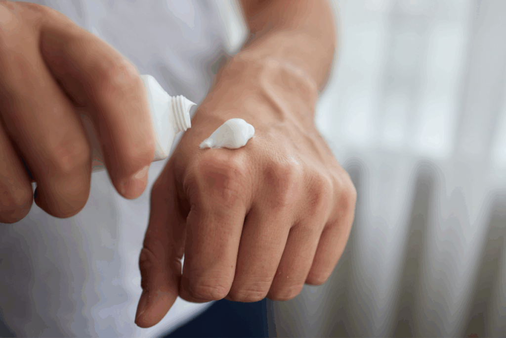 Mão masculina aplicando creme sobre a outra mão