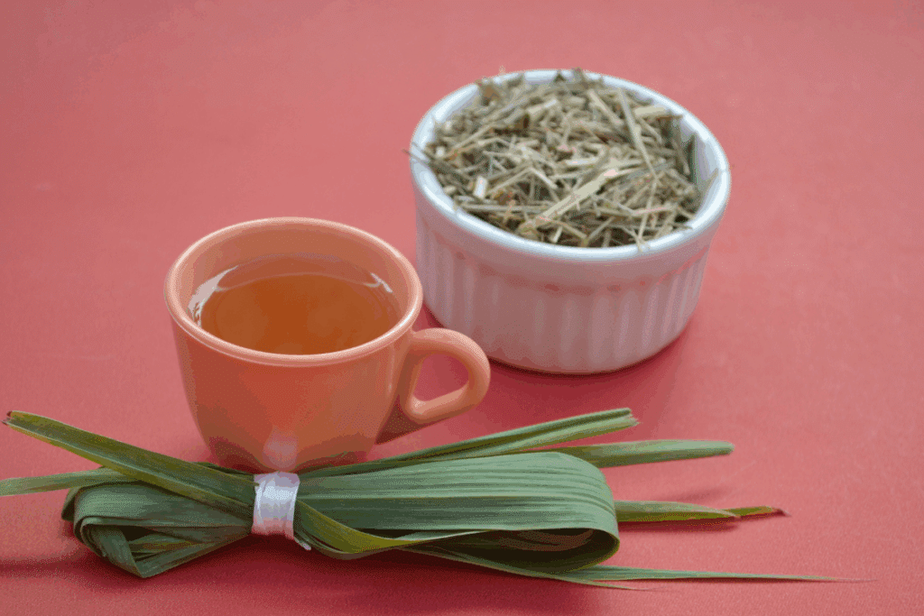 Erva-cidreira, chá de erva-cidreira e erva-cidreira seca em pote branco em cima de uma superfície rosa