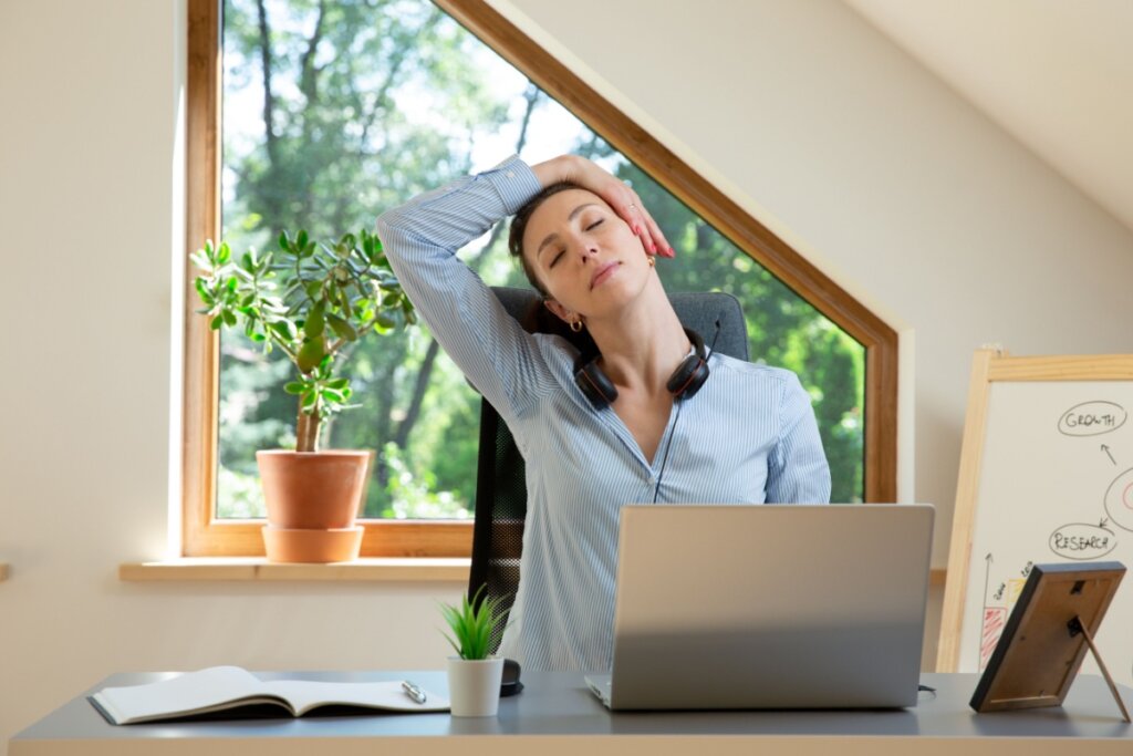 Mulher trabalhando de home office alongando durante o trabalho